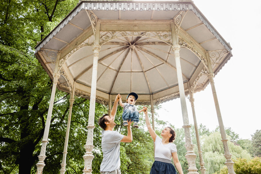 glückliche Familie spielt vor einem Pavillion im Palmengarten in Leipzig